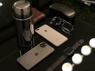 silver iphone 6 beside silver macbook and black framed eyeglasses