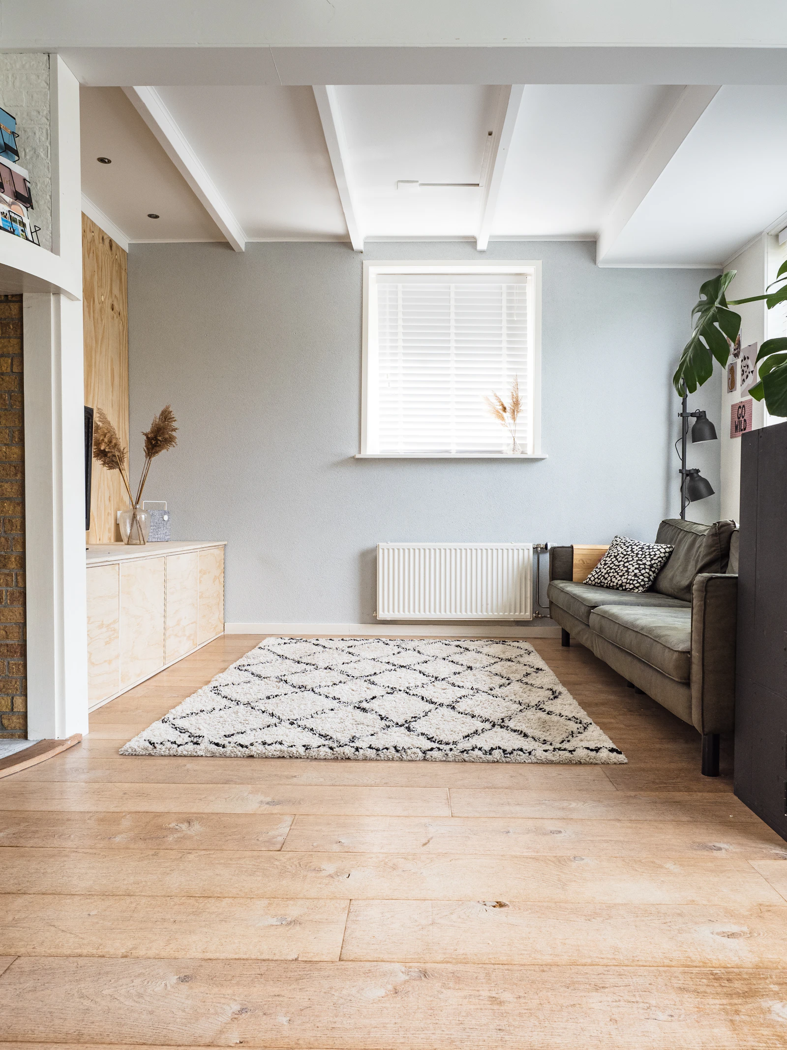 Salon lumineux avec tapis à motifs, canapé et parquet bois