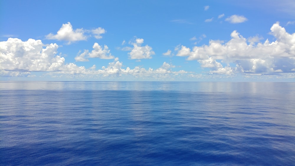 blue sea under blue sky and white clouds during daytime