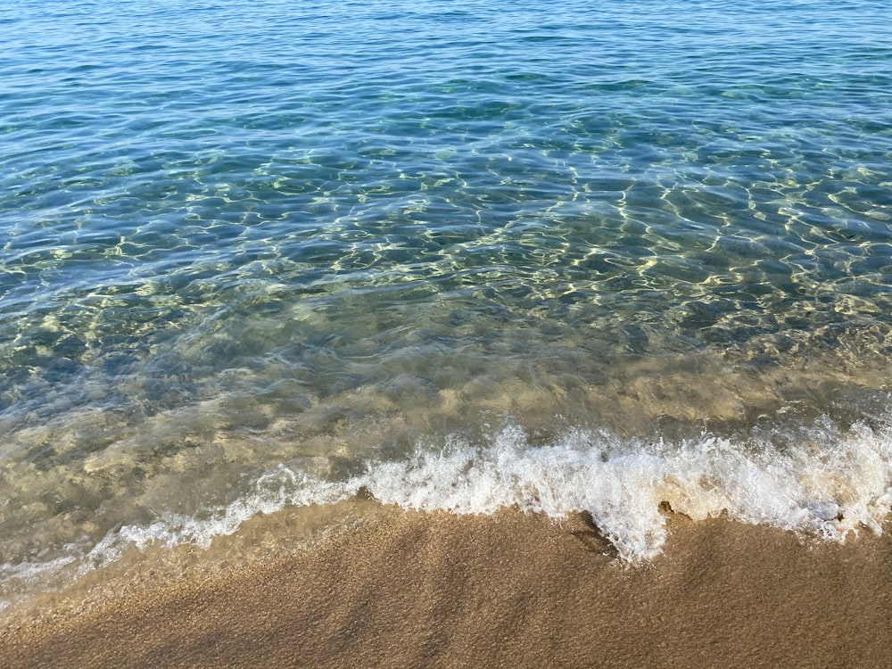 sea waves crashing on shore during daytime