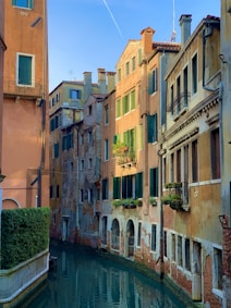 river between concrete buildings during daytime