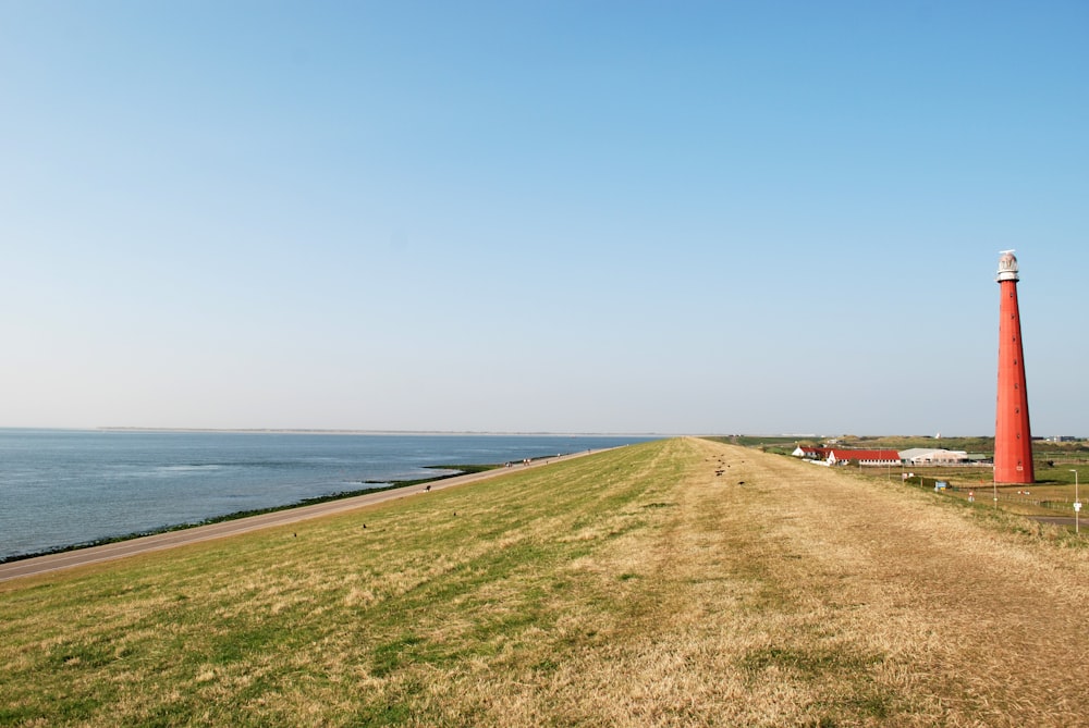 Rotes und weißes Haus in der Nähe von Meer unter blauem Himmel während des Tages