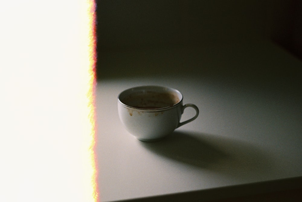 tazza da tè in ceramica bianca su tavolo bianco