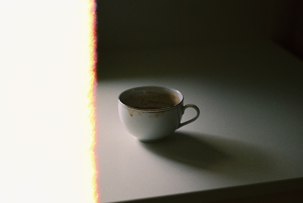 white ceramic teacup on white table
