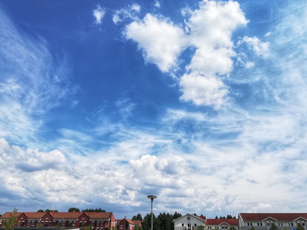 white and brown concrete buildings under blue sky and white clouds during daytime