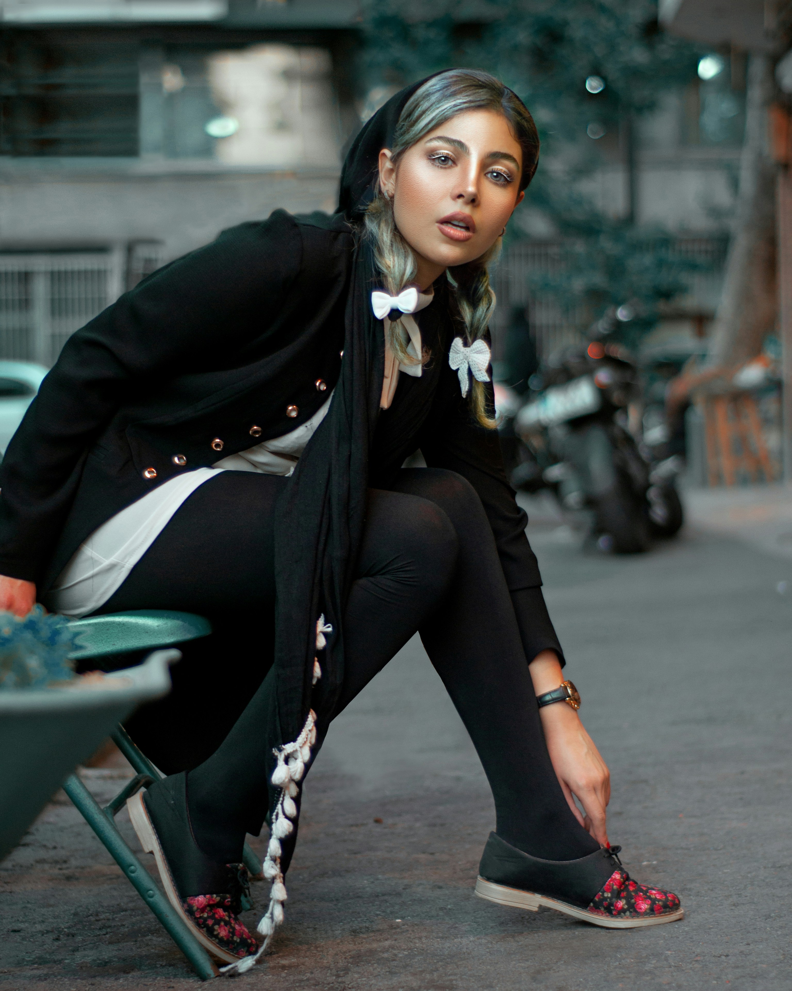 woman in black hoodie and black pants sitting on gray chair