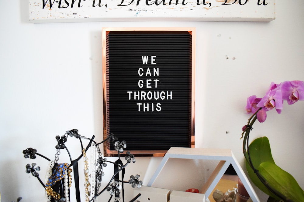 brown wooden signage mounted on white wall