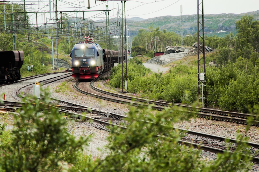 green and red train on rail tracks during daytime