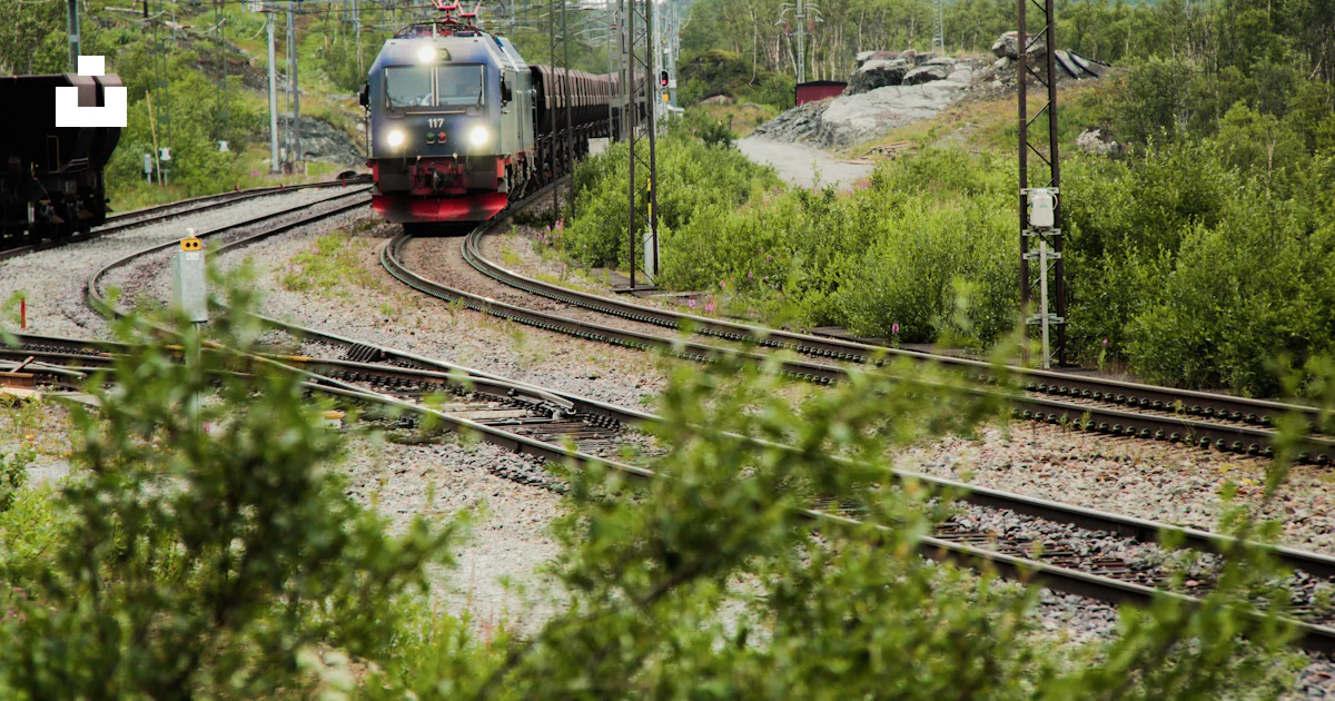 Green and red train on rail tracks during daytime photo – Free ...