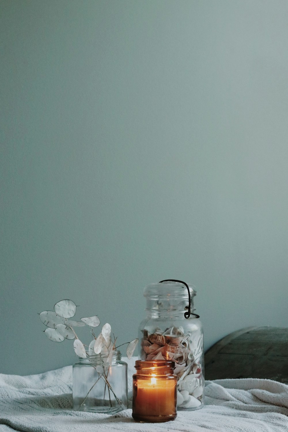 clear glass jar on white floral textile
