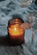 orange candle in clear glass jar