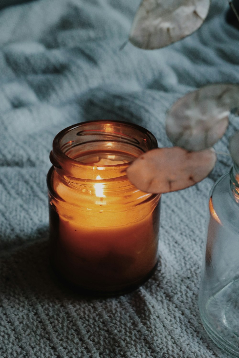 orange candle in clear glass jar