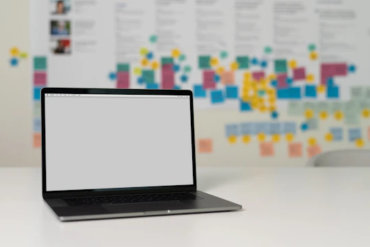 A creative professional brainstorming ideas with sticky notes and a laptop.