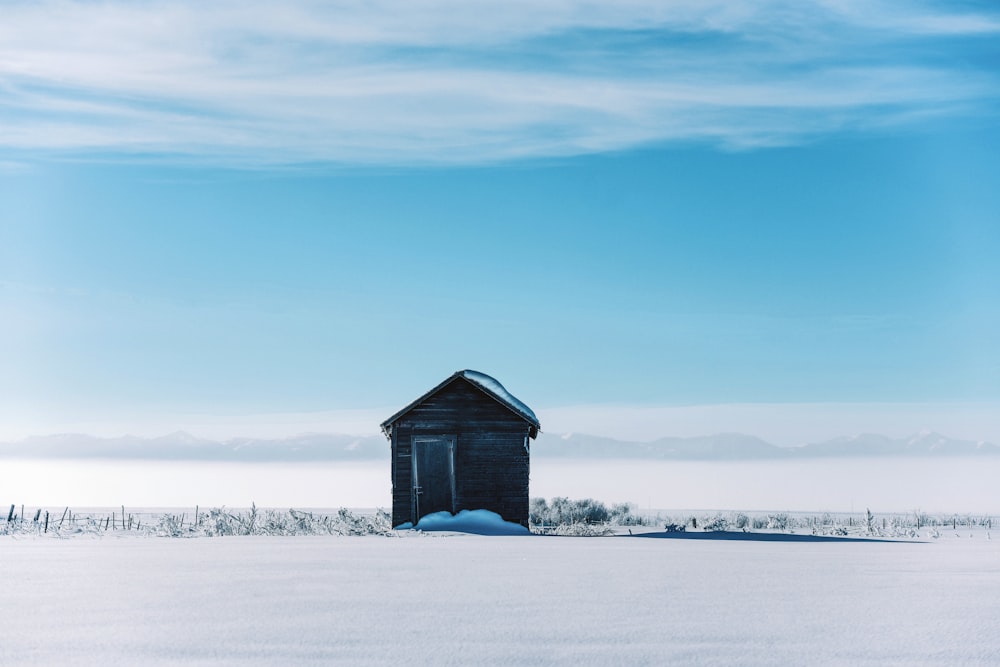 brown wooden house on snow covered ground during daytime