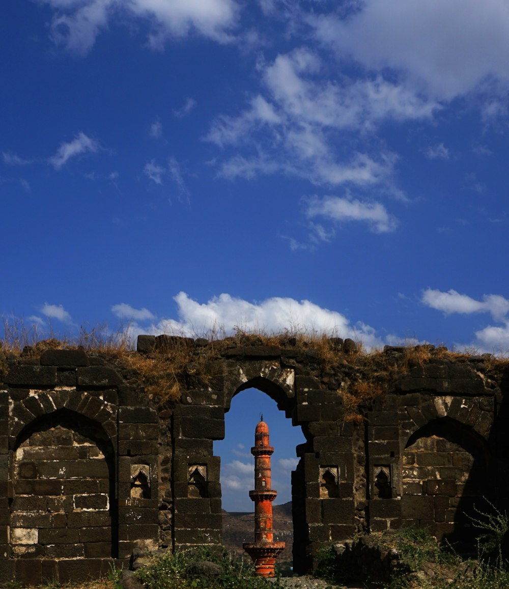 Arco de hormigón marrón bajo el cielo azul durante el día