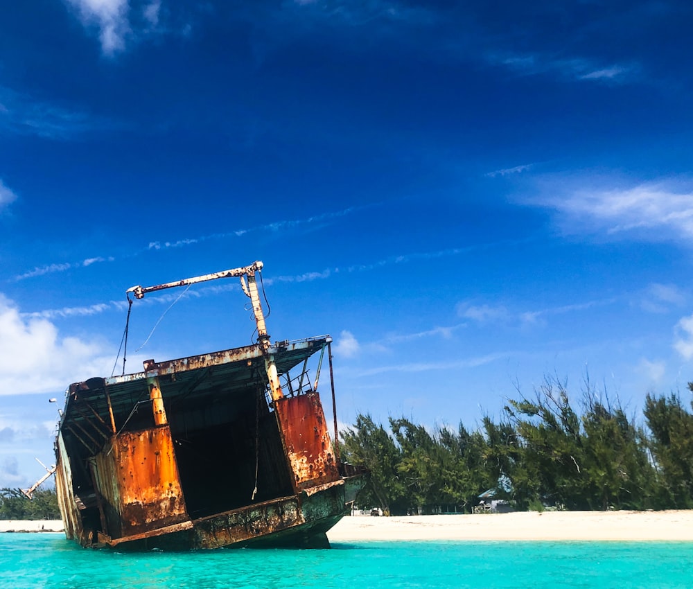 brown ship on sea under blue sky during daytime