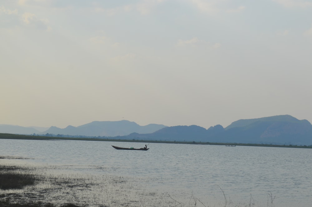 body of water near mountain during daytime