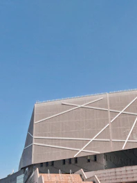 Modern architectural building with clean lines and metal accents under a clear sky.