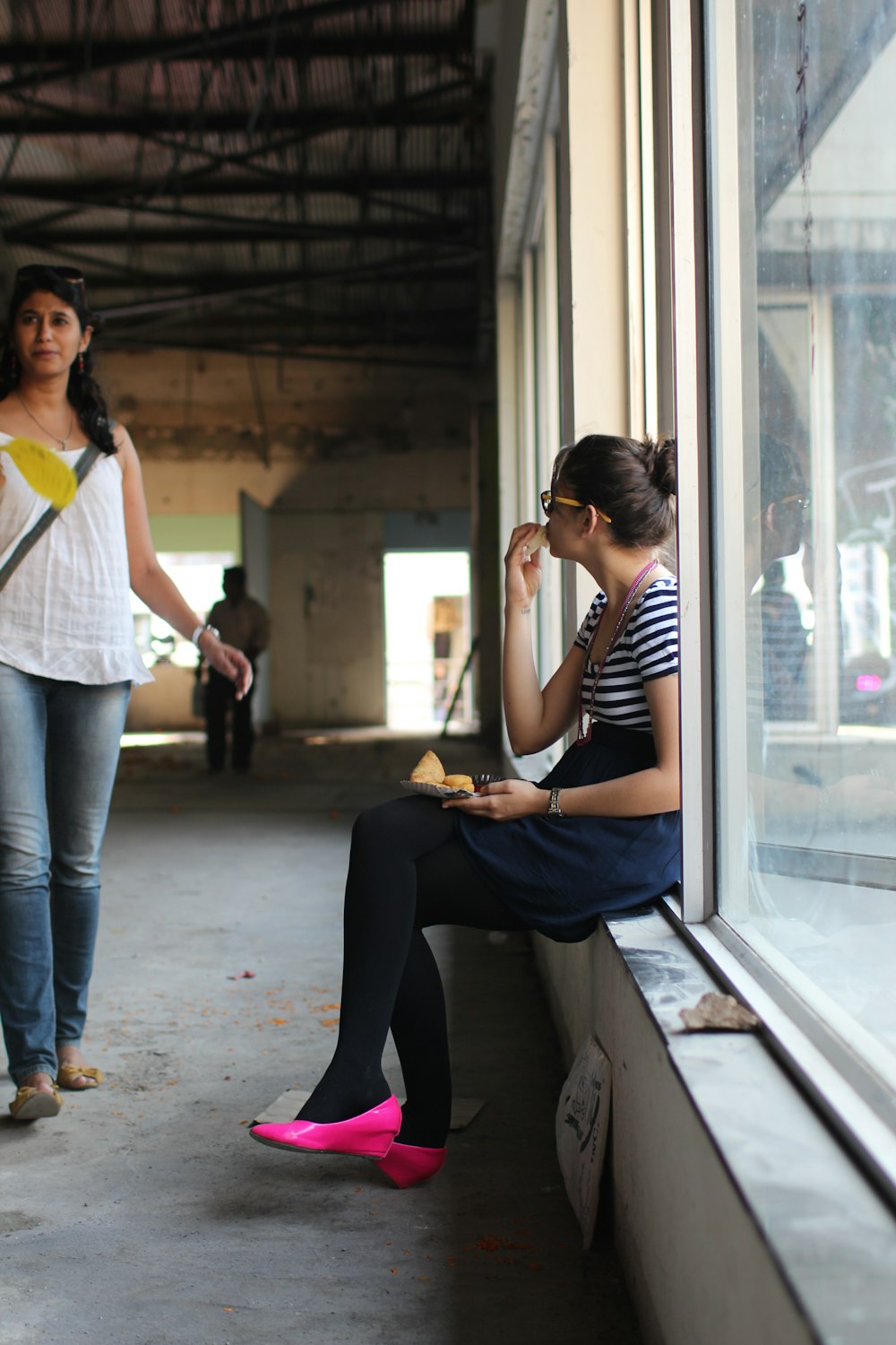 woman in blue denim jacket and black pants sitting on brown wooden bench