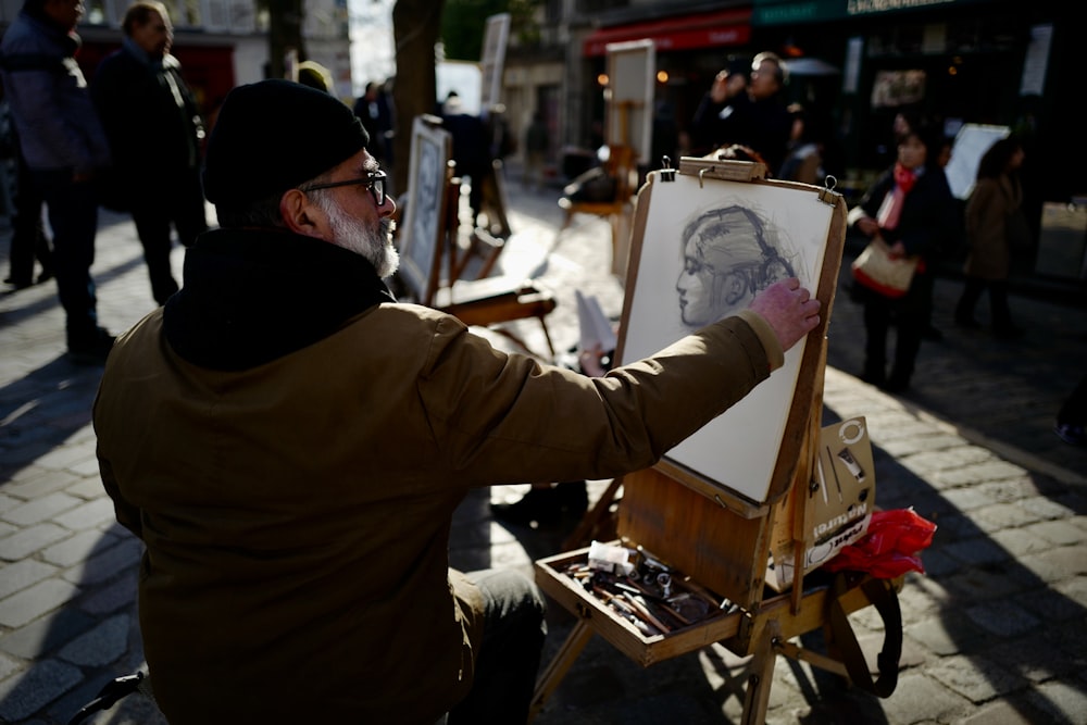 man in brown long sleeve shirt holding white and red floral painting