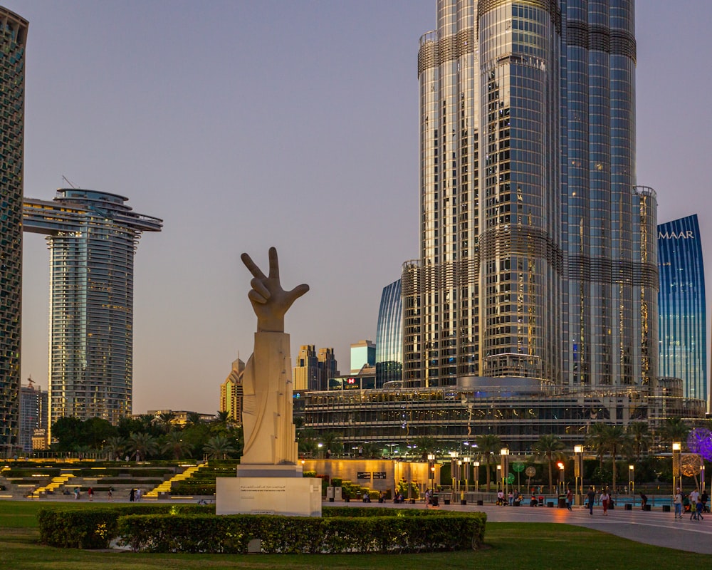 white concrete statue near high rise building during daytime