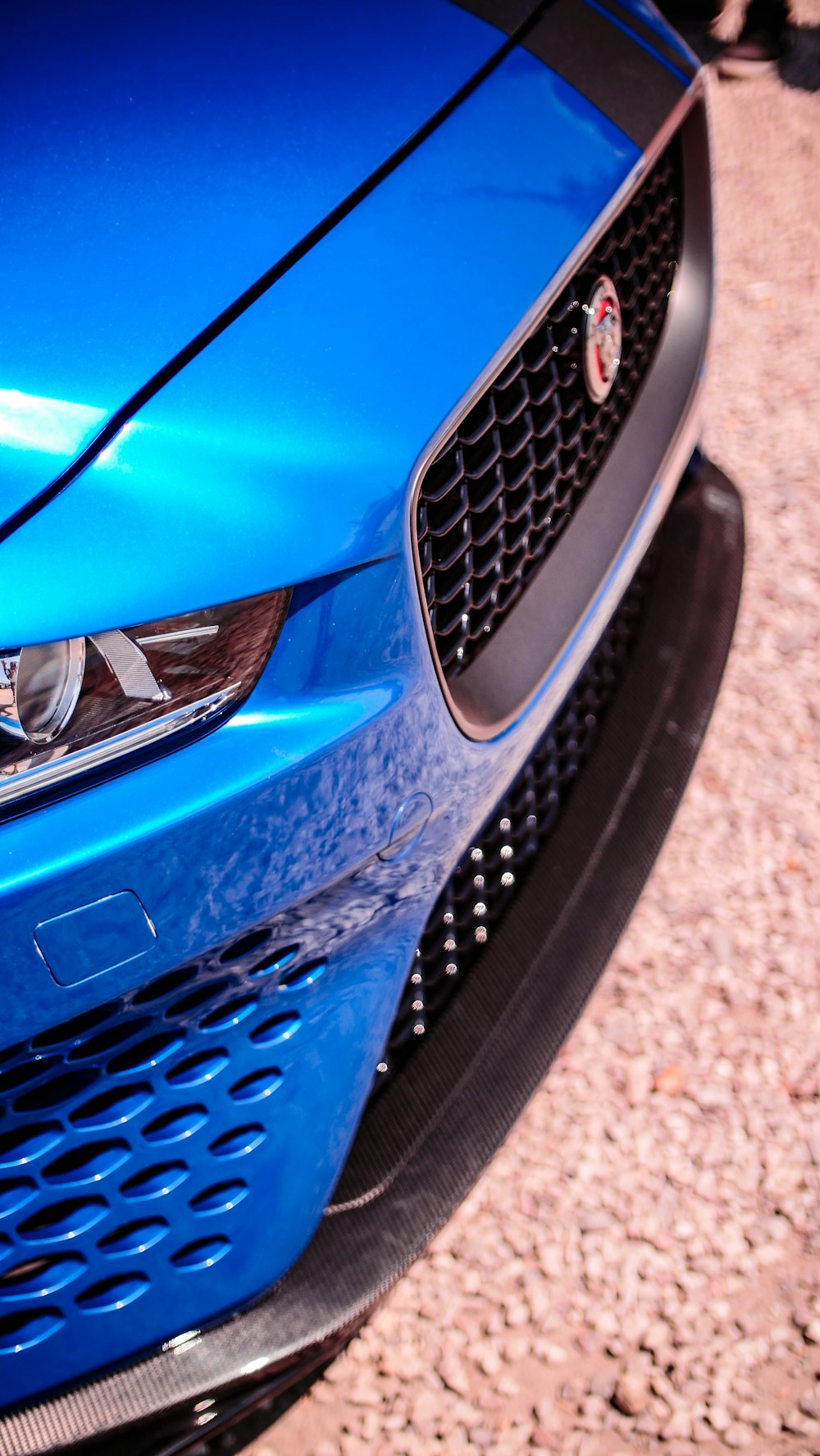 a close up of the front of a blue sports car