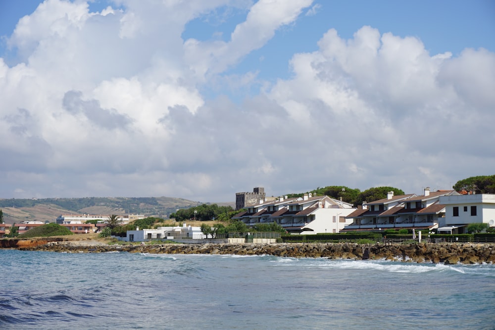 a large body of water with houses in the background