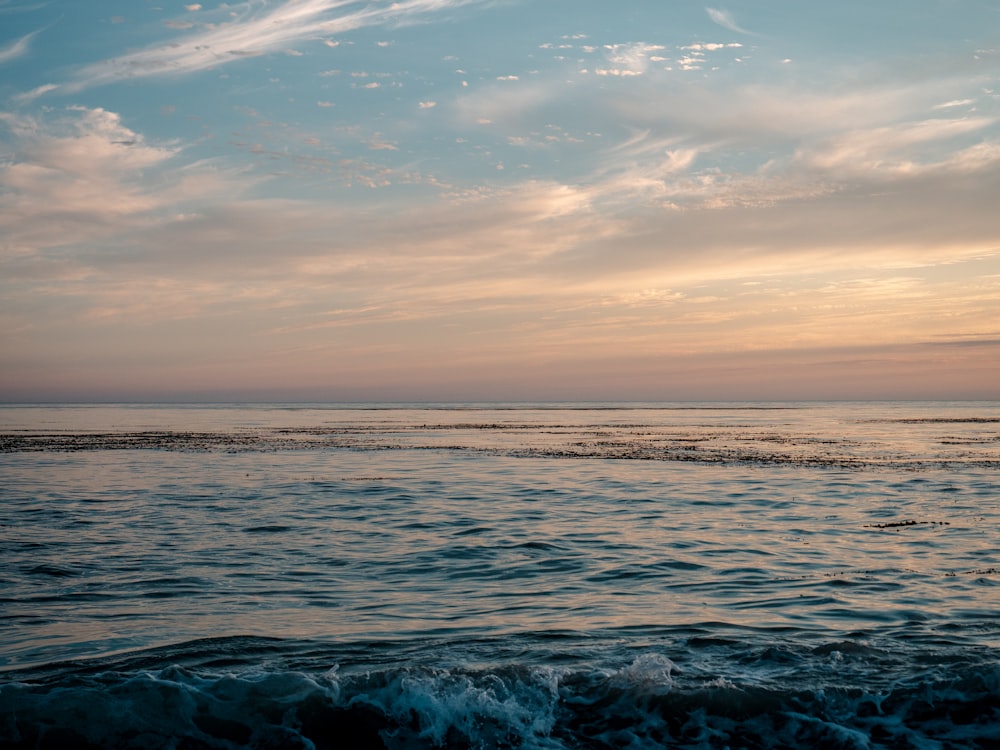 ocean waves under cloudy sky during daytime