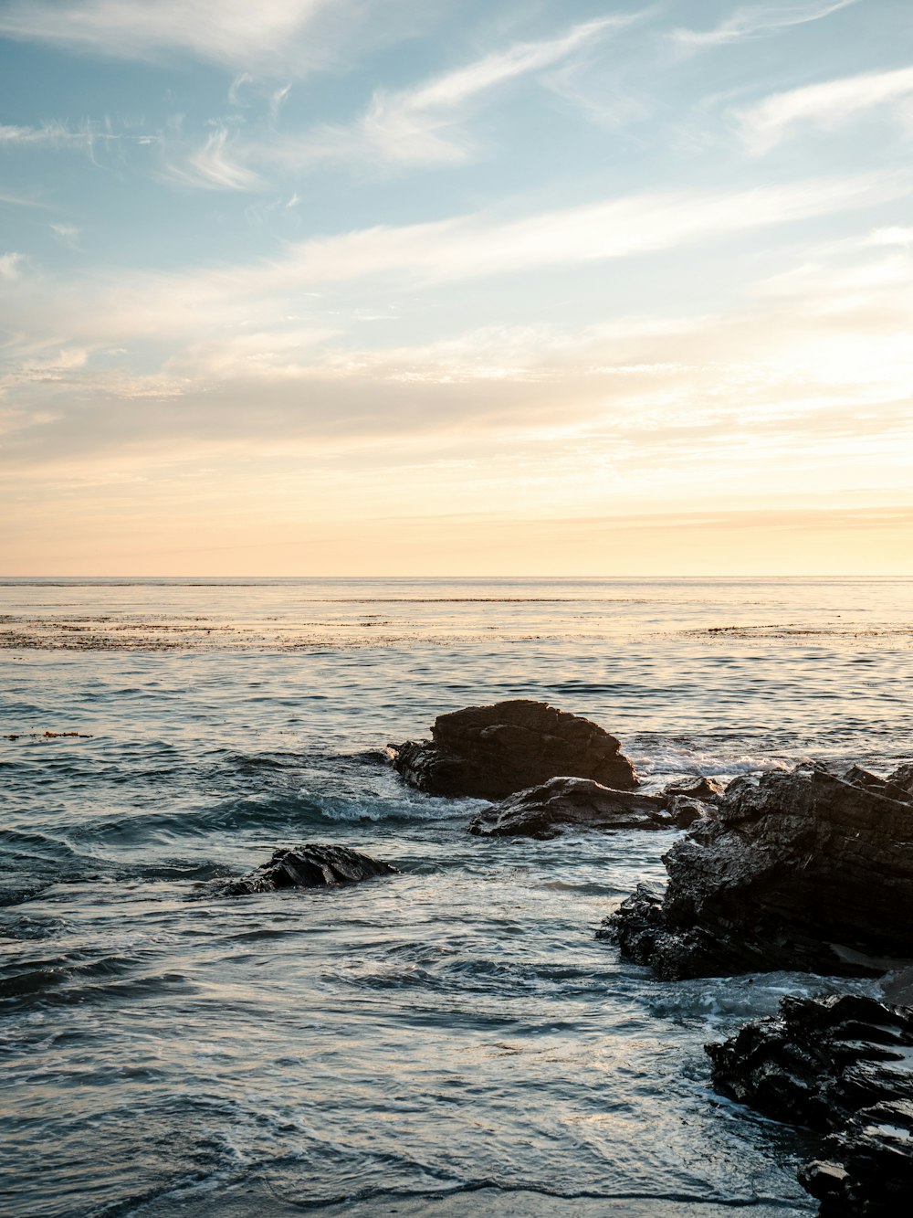 rocky shore under blue sky during sunset