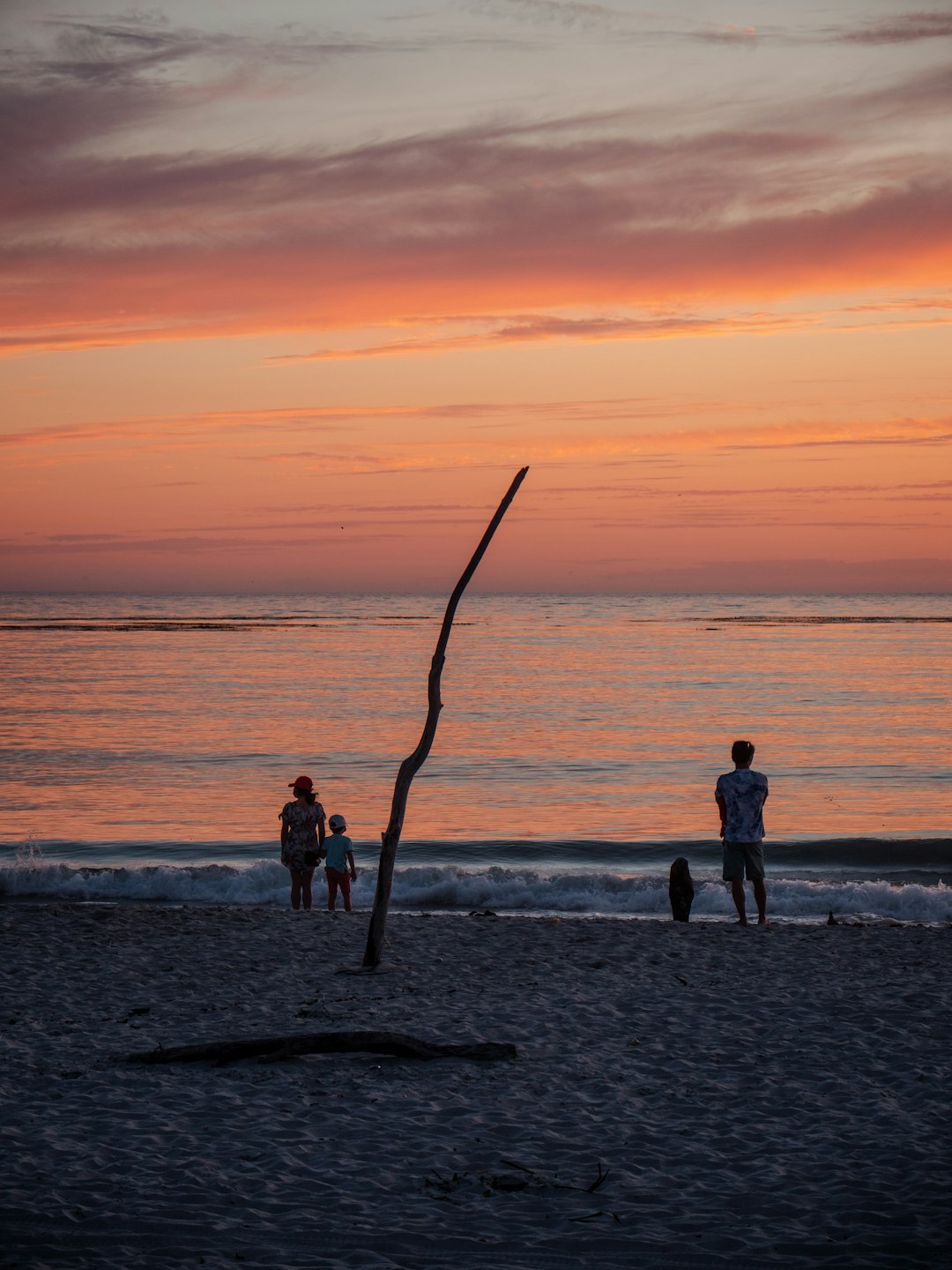 2 women standing on beach during sunset