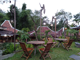 A serene outdoor classroom with natural wooden benches and traditional decorations.