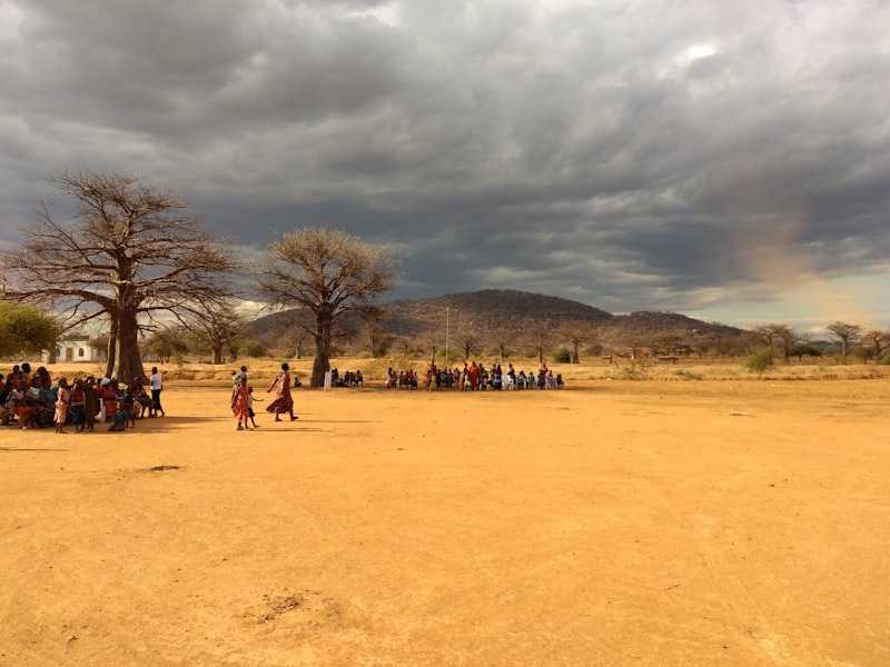 A community gathered outdoors in a rural East African field
