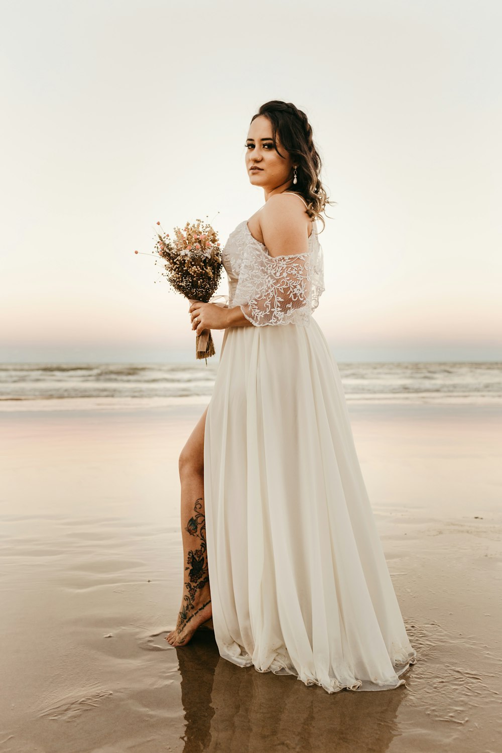 woman in white dress holding bouquet of flowers