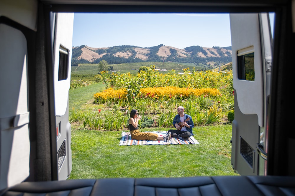 2 men sitting on green grass field during daytime