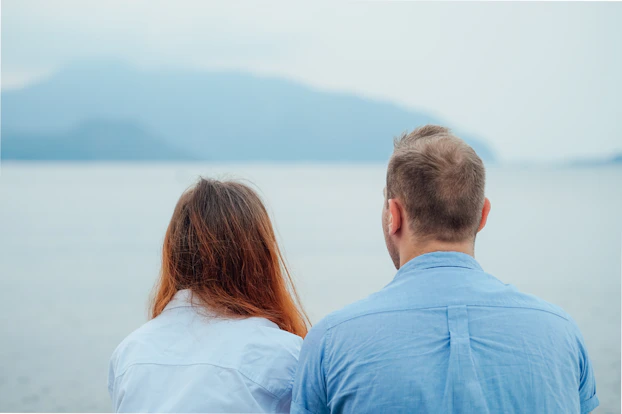 man in blue dress shirt beside woman in white shirt