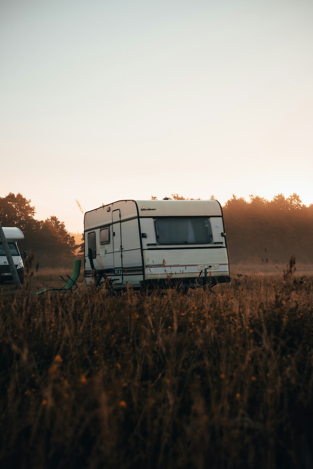 white and brown rv on brown grass field during daytime