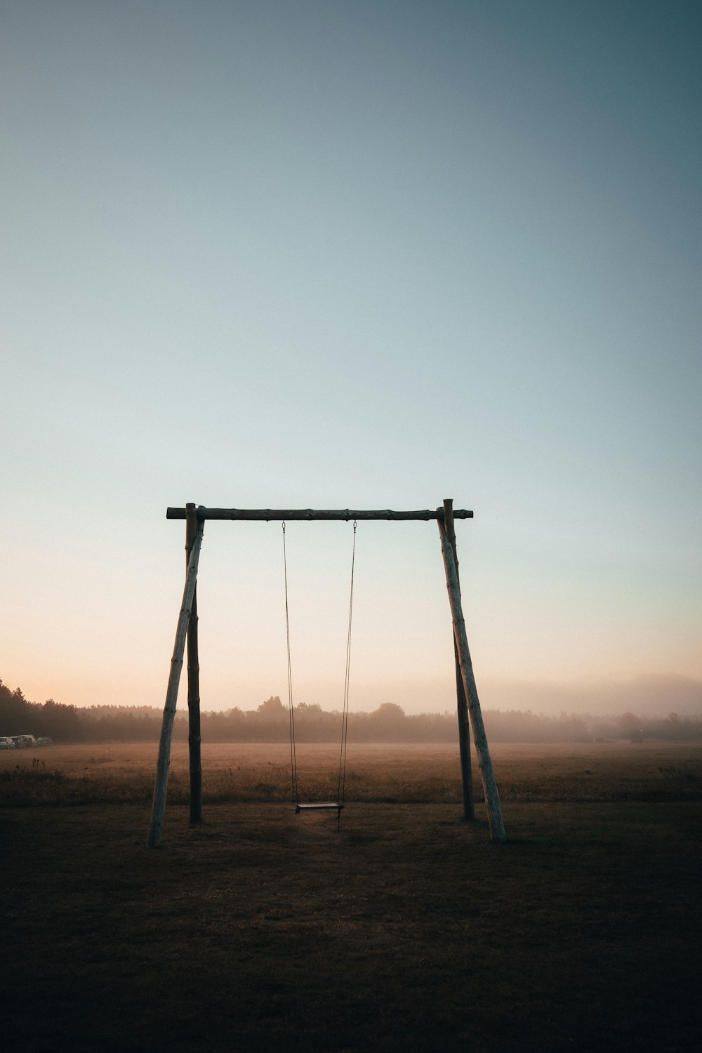 brown wooden swing under white sky during daytime