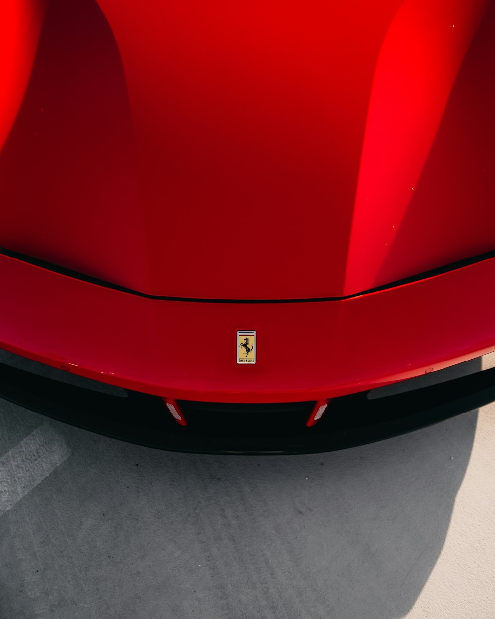 red ferrari car on gray concrete floor