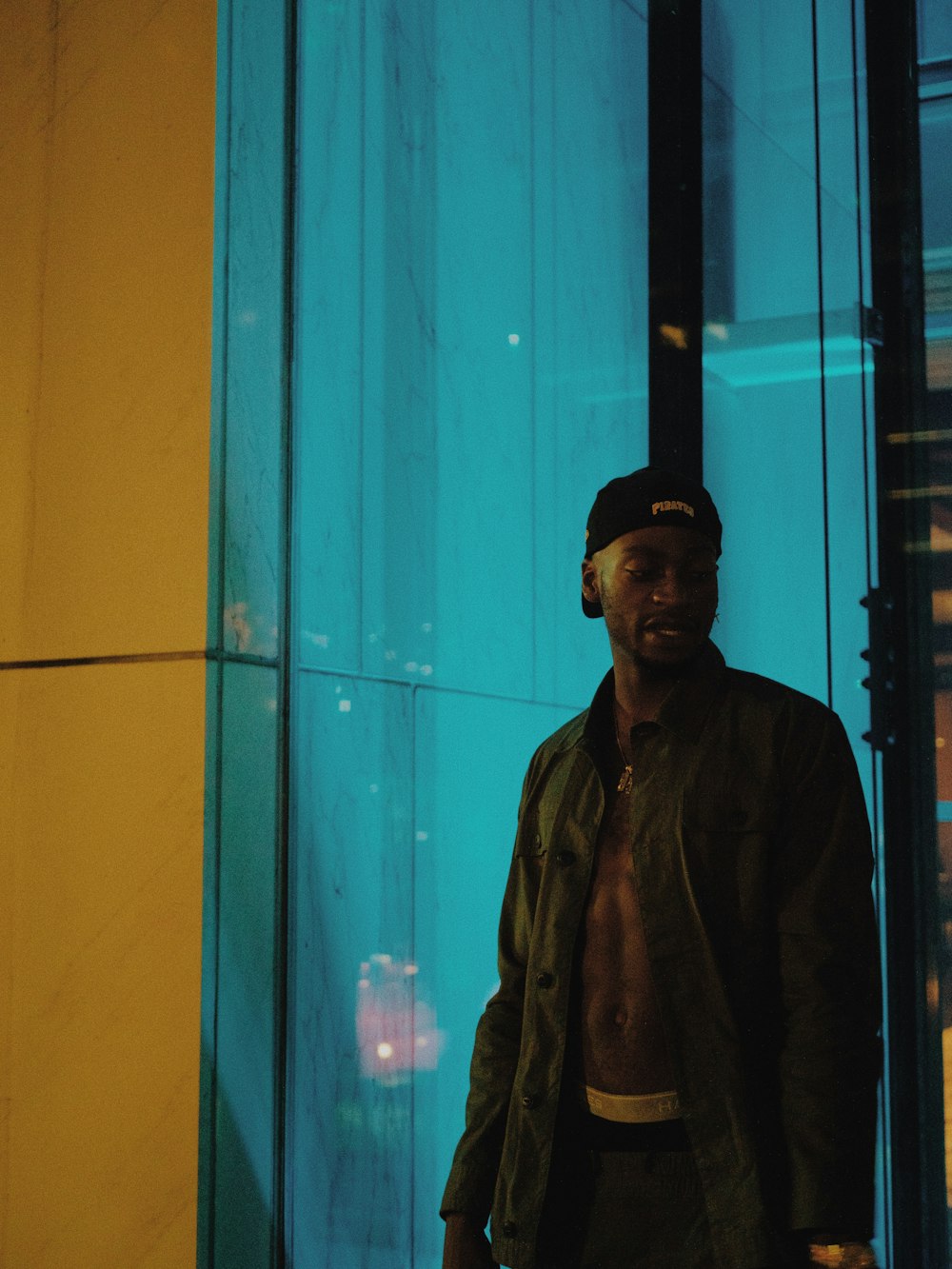man in black coat standing near glass window