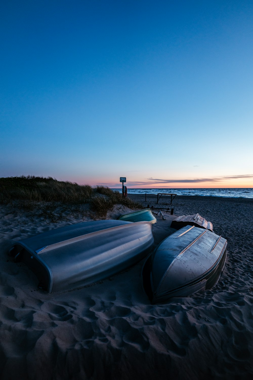 weißes und blaues Boot am Meeresufer bei Sonnenuntergang