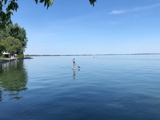 person in white shirt and shorts standing on body of water during daytime in Saint-Zotique Canada