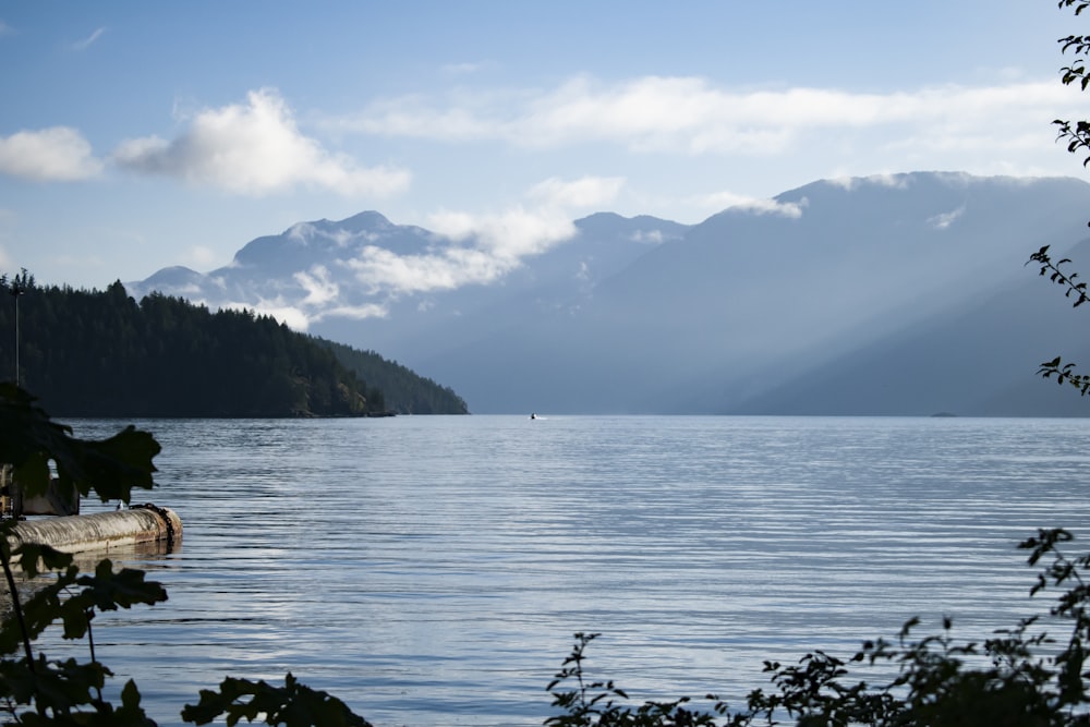 body of water near mountain during daytime