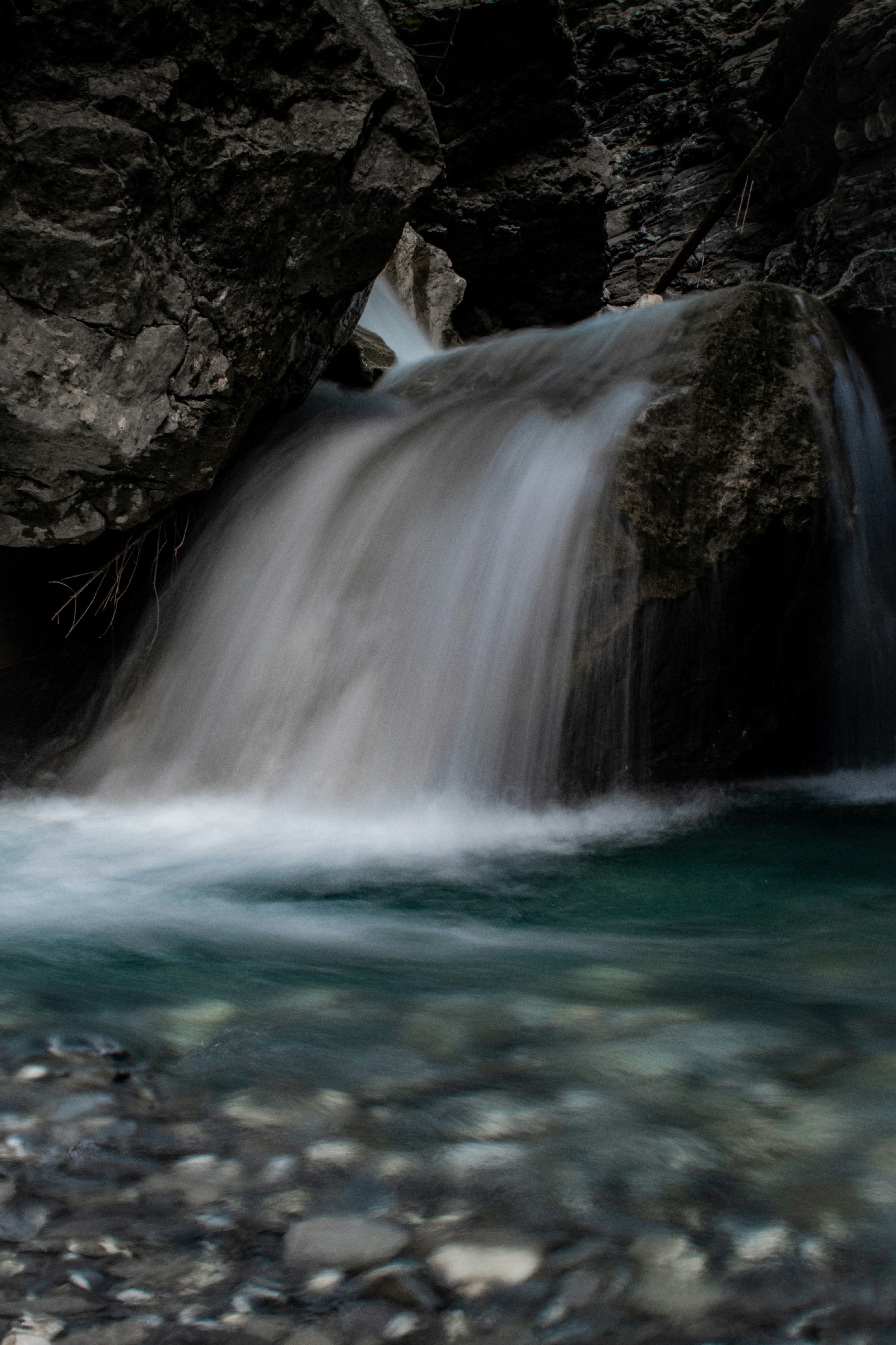 water falls on rocky shore during daytime