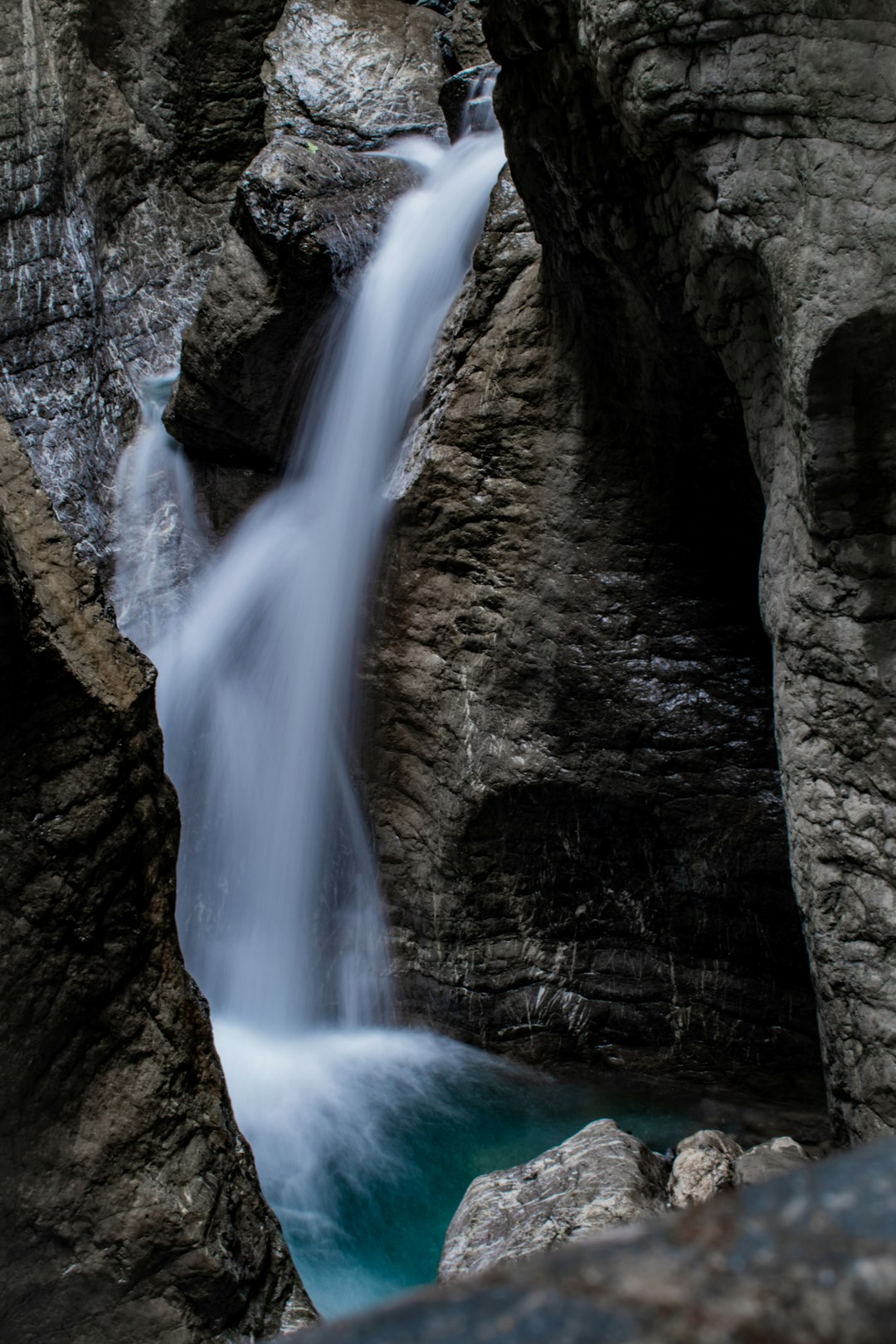 water falls on brown rocky mountain