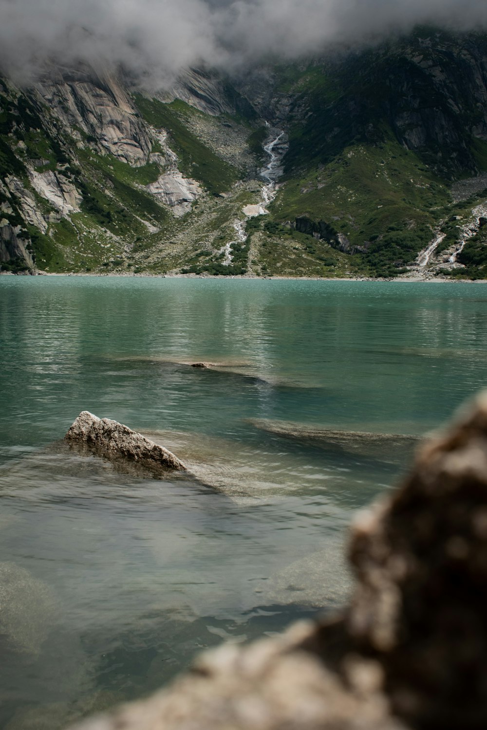 green and brown mountains beside body of water during daytime