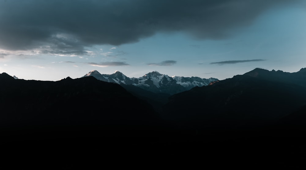 black and white mountains under cloudy sky during daytime