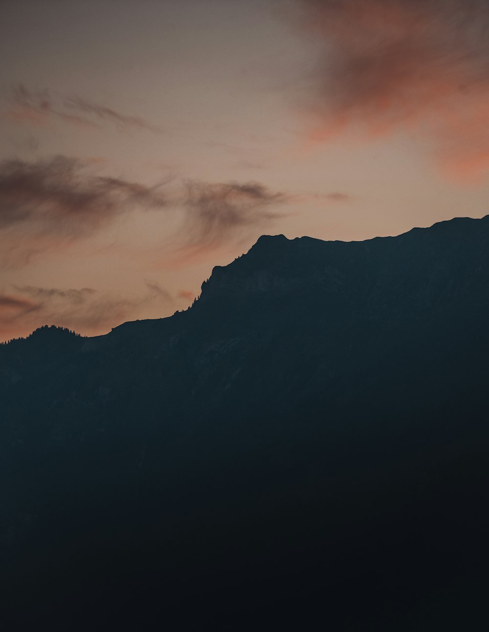 black and white mountain under cloudy sky