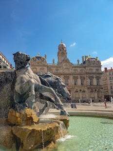 gray horse statue near brown concrete building under blue sky during daytime