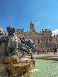 gray horse statue near brown concrete building under blue sky during daytime