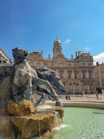 gray horse statue near brown concrete building under blue sky during daytime